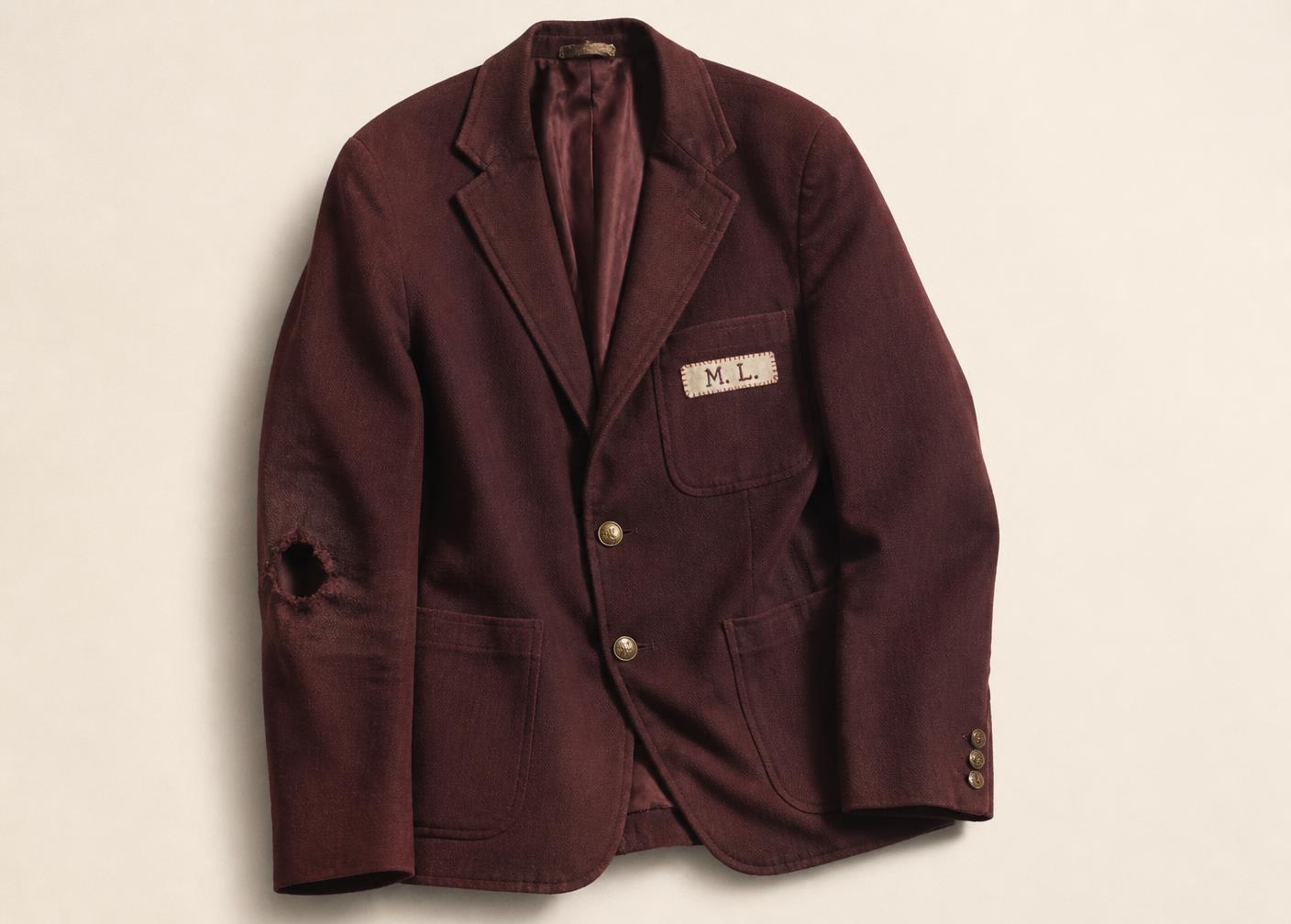 A 1984 maroon graduation blazer with a moth hole at the elbow